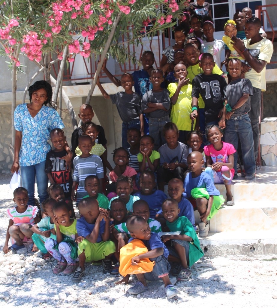 Groupe d'enfants souriant tenant des extraits d'actes de naissance de la République d'Haïti