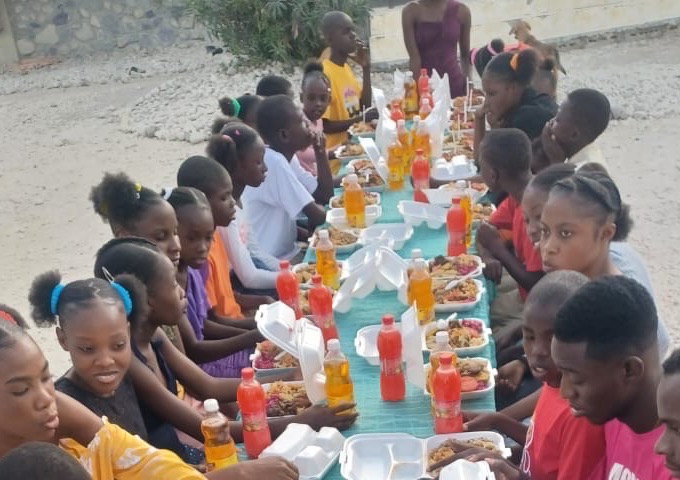Cantine scolaire : nombreux élèves attablés pour un repas, salle aux murs blancs et verts